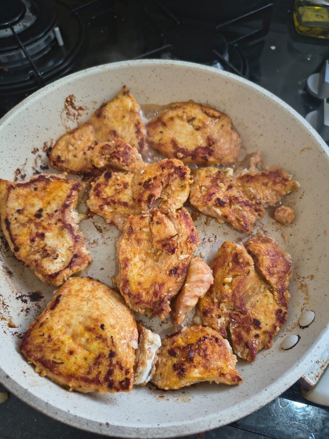 Filés de frango temperados dourando na frigideira